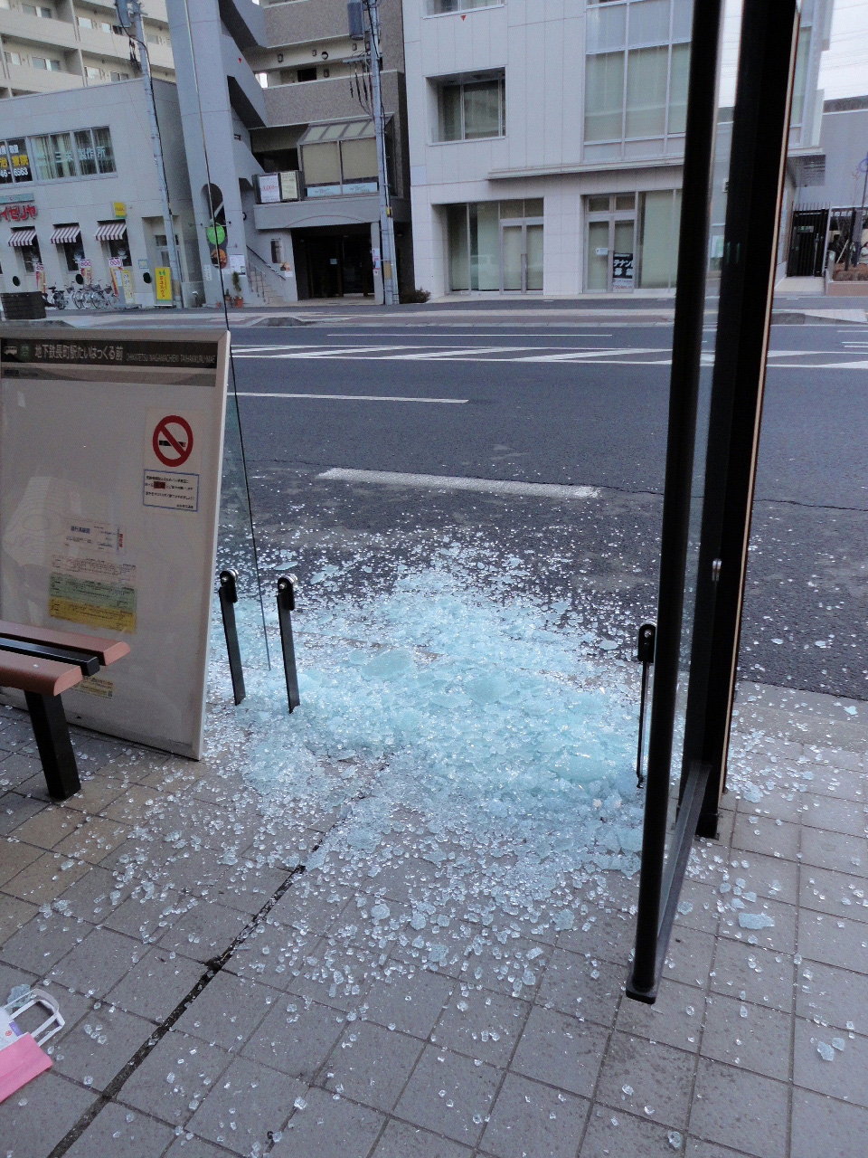 粉々に砕けたバス停のガラス