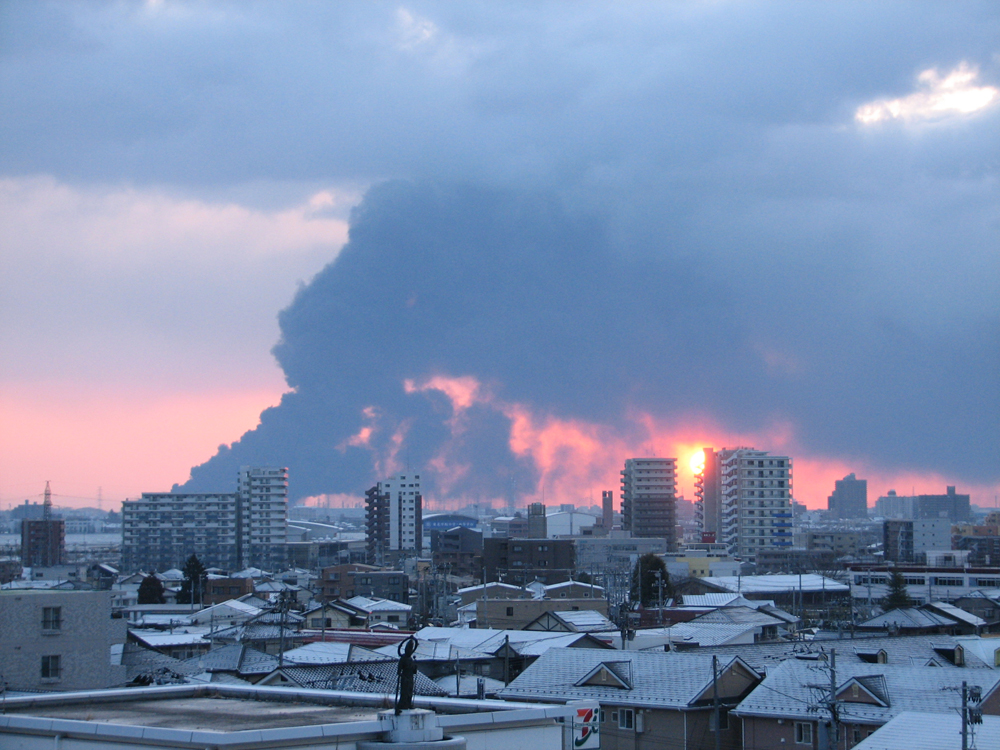 震災翌朝、仙台港の石油コンビナートから立ち上がる黒煙
