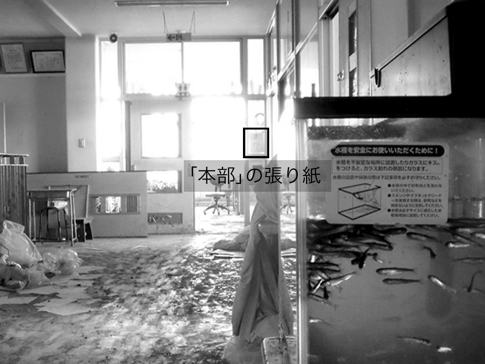 中野小学校_13-2_津波で2階も浸水したが七北田川に放流予定のサケの稚魚は無事だった。職員室入り口のガラスに「本部」の張り紙がみえる。
